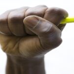 photo of hand fisted and holding pencil