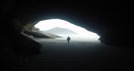 photo of a person exiting a cave