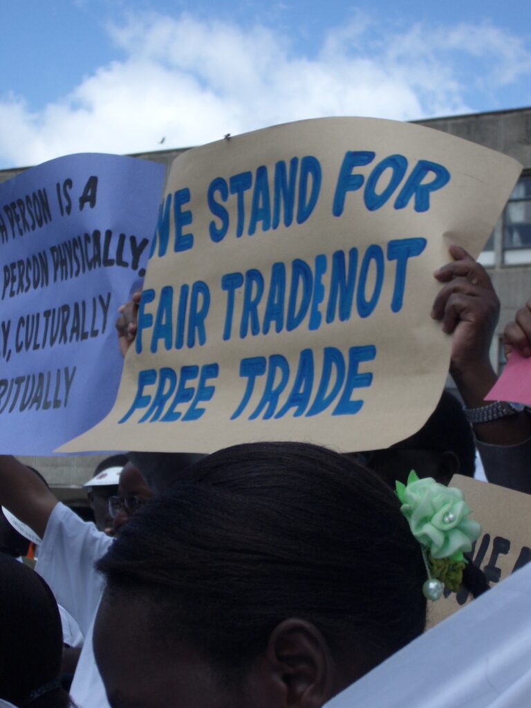A photo of a demonstration with a sign that reads, "We stand for fair trade, not free trade."