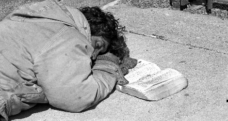 Photo of sleeping homeless man with open Bible