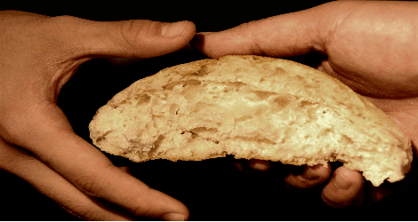 photo of two hands sharing bread